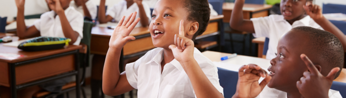 Kids showing hands during a lesson at an elementary school.