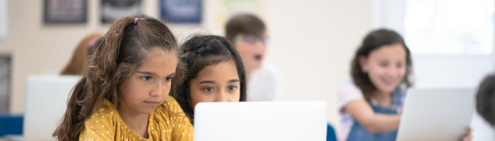 Niña en aula utilizando computadora